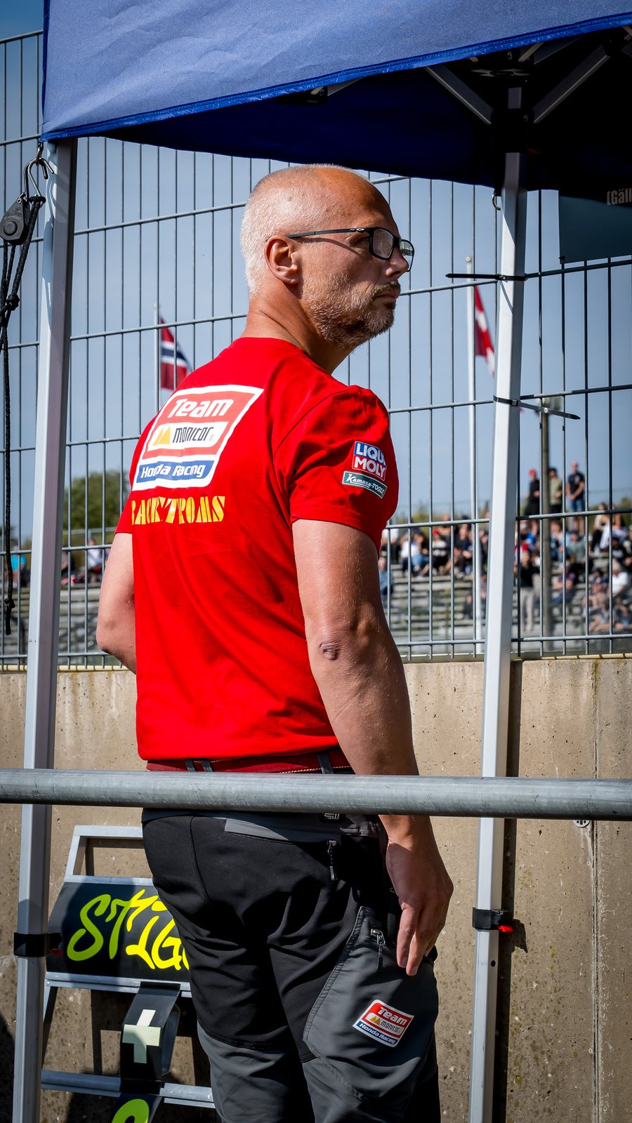Fredrik Stigefelt i teamets röda tröja vid depåmuren